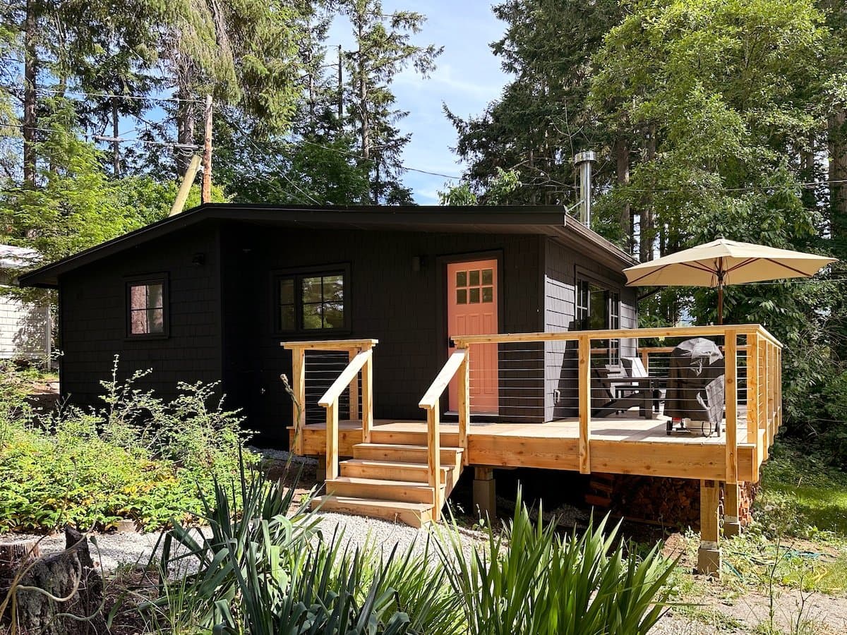Cabin 6 finished — dark siding, cedar stairs and deck at St Mary's Lake